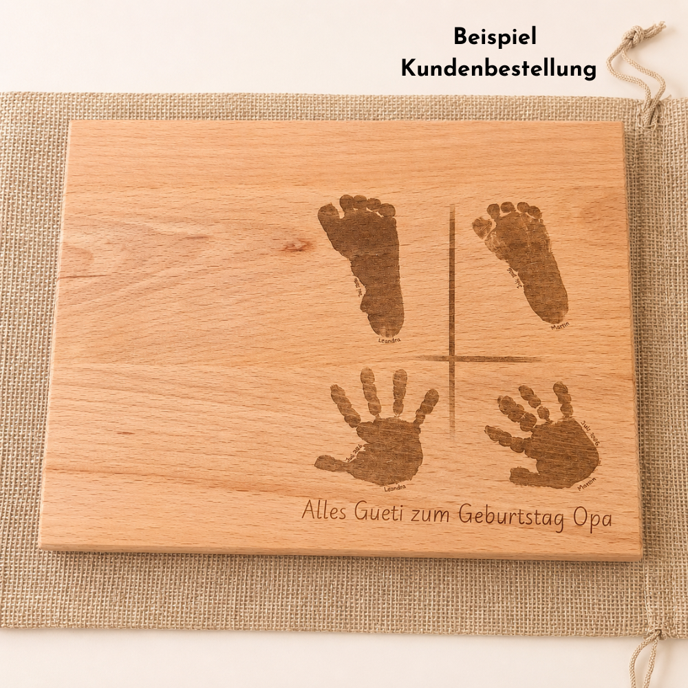 Beispiel einer Kundenbestellung: personalisiertes Holzschneidebrett mit zwei Handabdrücken, zwei Fussabdrücken und der Gravur «Alles Gueti zum Geburtstag Opa».