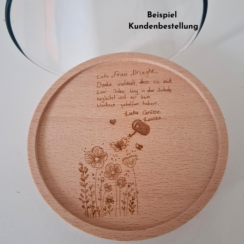 Runder Holzdeckel für Vorratsglas mit graviertem Wunschtext und Blumenmotiv als Abschiedsgeschenk für eine Lehrperson.