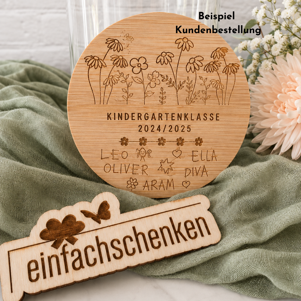 Beispiel einer Kundenbestellung: personalisiertes Vorratsglas mit graviertem Holzdeckel, Blumenmotiv, «Kindergartenklasse 2024/2025» sowie Namen und Zeichnungen der Kinder als Abschiedsgeschenk.