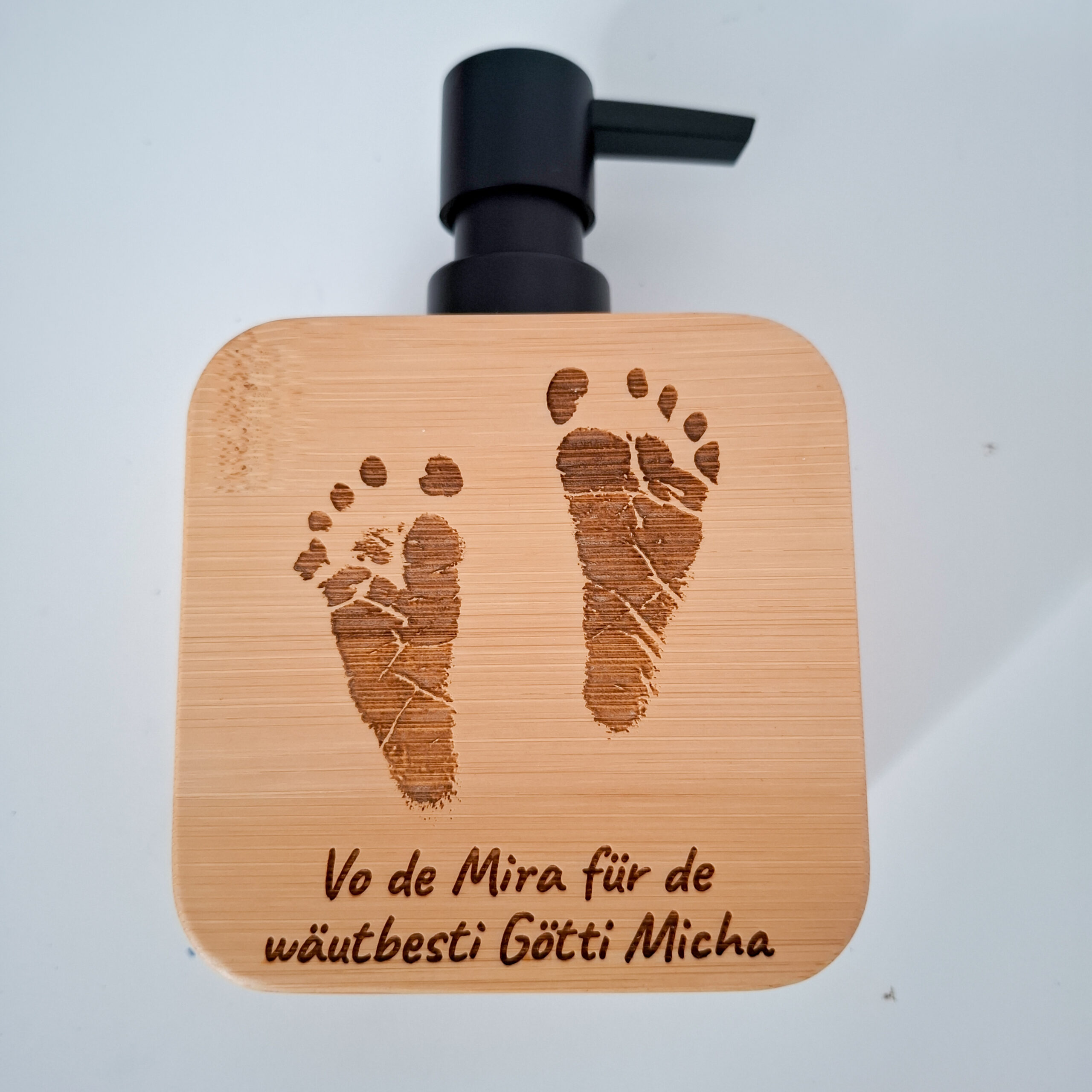 Personalisierter Seifenspender aus Bambus mit gravierten Baby-Fussabdrücken und individueller Widmung – Beispiel einer Kundenbestellung als Geschenk für ein Götti