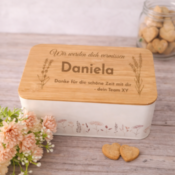 Personalisierte Keksdose mit Bambusdeckel und Gravur „Wir werden dich vermissen Daniela“, liebevolles Abschiedsgeschenk vom Team für Kollegin.