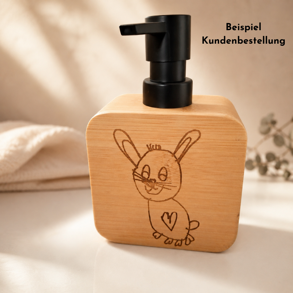 Beispiel einer Kundenbestellung: personalisierter Seifenspender mit Holzgehäuse und schwarzem Pumpspender, graviert mit einer Kinderzeichnung eines Hasen als persönliches Geschenk.