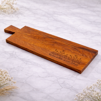 Personalisiertes Schneidebrett aus Eichenholz mit floraler Gravur und eingraviertem Spruch im unteren Bereich.