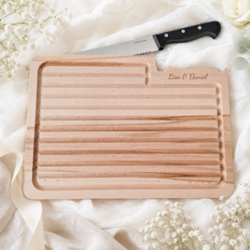 Personalisiertes Schneidebrett mit Messer und Namensgravur als Hochzeitsgeschenk für ein Paar.