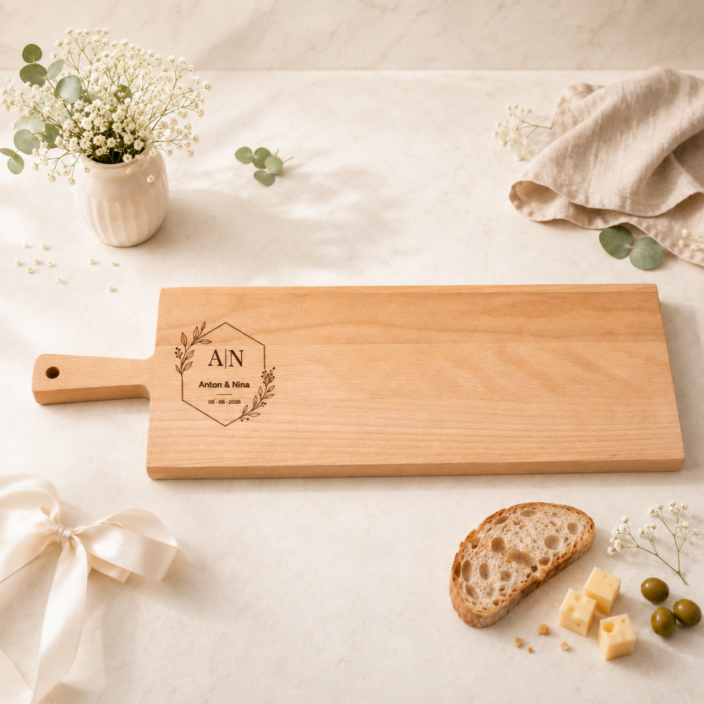 Apérobrett aus Buchenholz mit Griff, personalisiert mit Hochzeitsgravur: Initialen in geometrischem Sechseck mit Blattranken, Namen Anton und Nina sowie Hochzeitsdatum